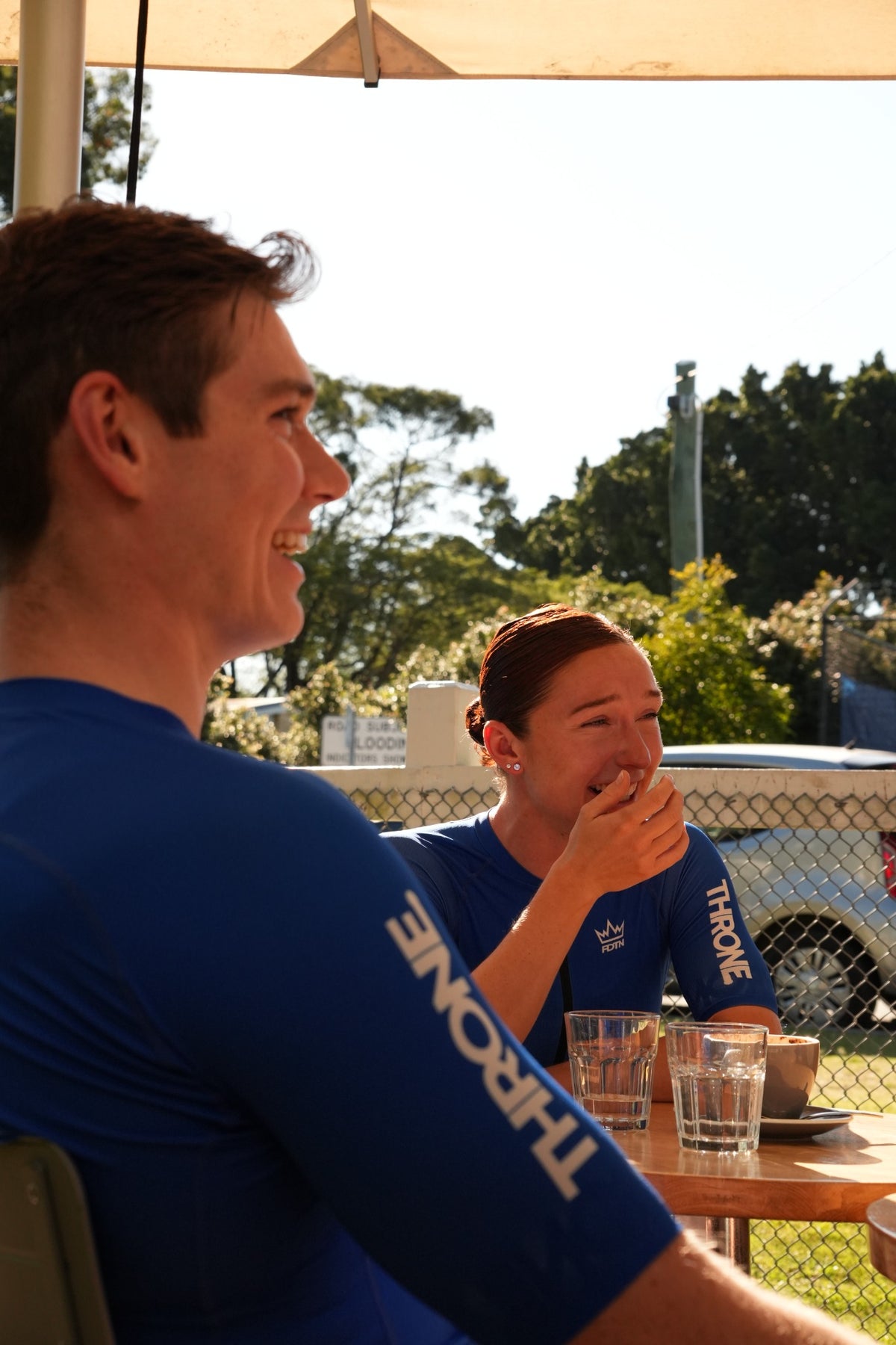 THRONE. FOUNDATION cyclists in blue kit at a relaxed post-ride cafe stop